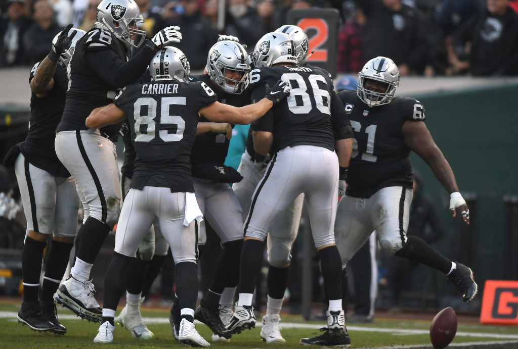 OAKLAND, CA - DECEMBER 09:  Derek Carr #4 of the Oakland Raiders (C) celebrates with teammates after he threw a touchdown pass against the Pittsburgh Steelers during the second half of an NFL football game at Oakland-Alameda County Coliseum on December 9, 2018 in Oakland, California.  (Photo by Thearon W. Henderson/Getty Images)