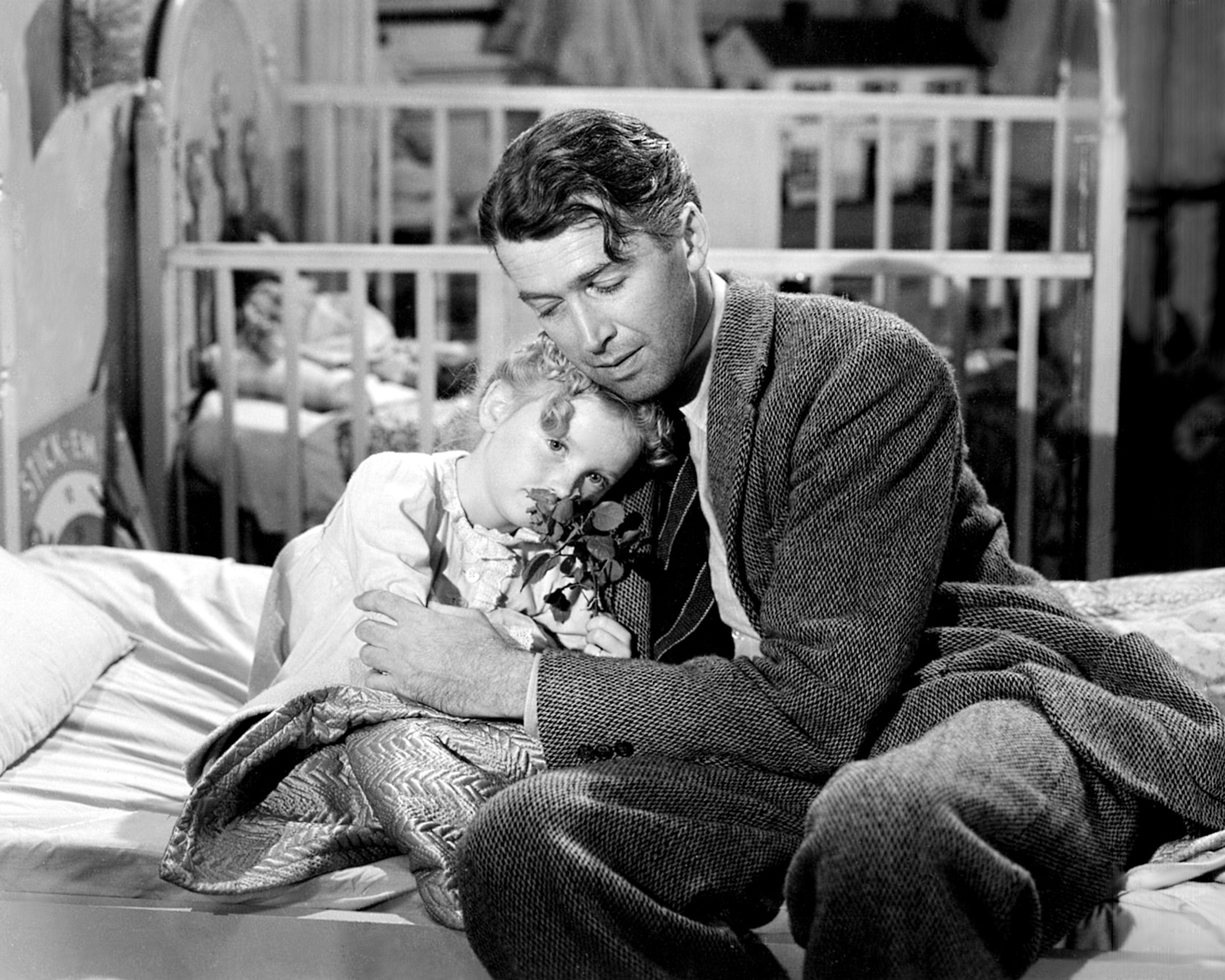 American actors James Stewart (1908 - 1997), as George Bailey, and Karolyn Grimes as his daughter Zuzu, in a scene from 'It's a Wonderful Life', directed by Frank Capra, 1946. (Getty Images)