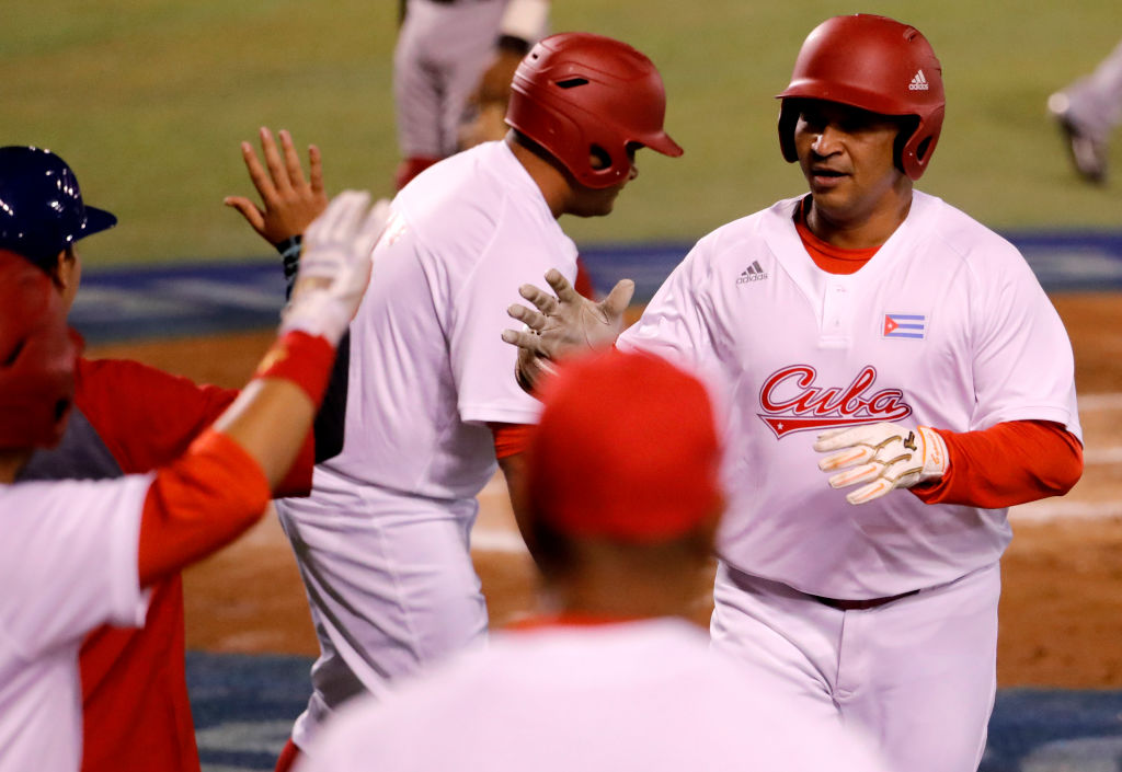 Frederich Cepeda (R) of Alazanes del Granma of Cuba celebrates after scoring against Aguilas Cibaenas of República Dominicana during the Caribbean Baseball Series at the Charros Jalisco stadium in Guadalajara, Jalisco state, Mexico, on February 7, 2018. / AFP PHOTO / ULISES RUIZ        (Photo credit should read ULISES RUIZ/AFP/Getty Images)