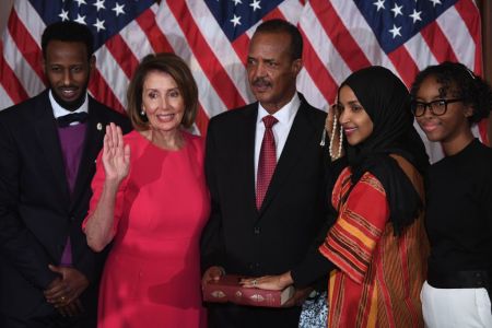 US House Representative Ilhan Omar (2nd-R), D-MN, with her hand on the Quran, participates in a ceremonial swearing-in with Speaker of the House Nancy Pelosi (2nd-L), D-CA,  during the start of the 116th Congress at the US Capitol in Washington, DC, January 3, 2019. (Photo by SAUL LOEB / AFP)        (Photo credit should read SAUL LOEB/AFP/Getty Images)