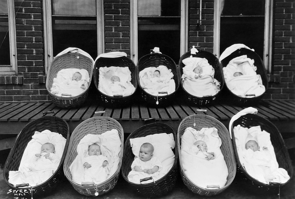Ten babies, all but one sleeping, rest in baskets on a porch outside of a maternity ward. (Photo by © Minnesota Historical Society/CORBIS/Corbis via Getty Images)