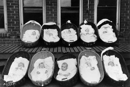 Ten babies, all but one sleeping, rest in baskets on a porch outside of a maternity ward. (Photo by © Minnesota Historical Society/CORBIS/Corbis via Getty Images)