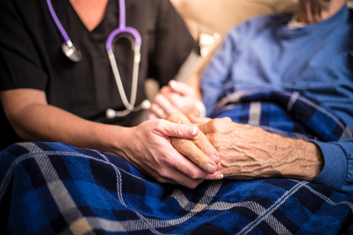 A hospice nurse visits an elderly patient. (Getty Images)