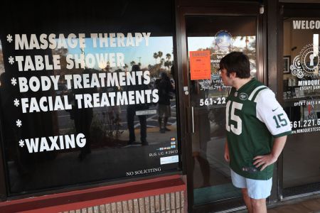 Matthew Gizze,  a N.Y. Jet football fan,  stops to look at the Orchids of Asia Day Spa where New England Patriots owner Robert Kraft is charged with allegedly soliciting for sex on February 22, 2019 in Jupiter, Florida.  (Photo by Joe Raedle/Getty Images)