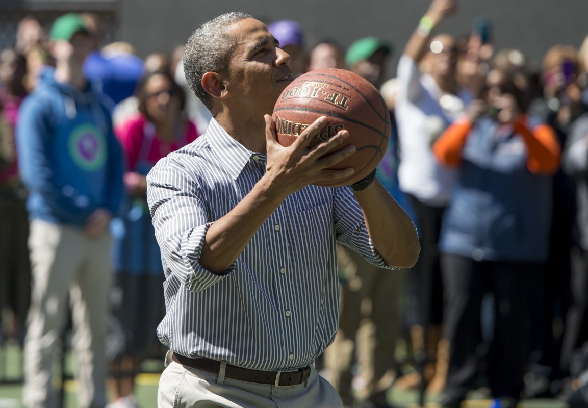 US President Barack Obama shoots a basketball during the annual White House Easter Egg Roll on the South Lawn of the White House in Washington, DC, April 21, 2014. The 126th annual White House Easter Egg Roll, the largest annual public event at the White House with more than 30,000 attendees expected, features live music, sports courts, cooking stations, storytelling and Easter egg rolling, with the theme, "Hop into Healthy, Swing into Shape." AFP PHOTO / Saul LOEB        (Photo credit should read SAUL LOEB/AFP/Getty Images)