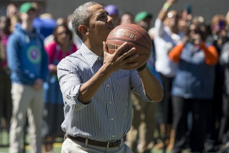 US President Barack Obama shoots a basketball during the annual White House Easter Egg Roll on the South Lawn of the White House in Washington, DC, April 21, 2014. The 126th annual White House Easter Egg Roll, the largest annual public event at the White House with more than 30,000 attendees expected, features live music, sports courts, cooking stations, storytelling and Easter egg rolling, with the theme, "Hop into Healthy, Swing into Shape." AFP PHOTO / Saul LOEB        (Photo credit should read SAUL LOEB/AFP/Getty Images)