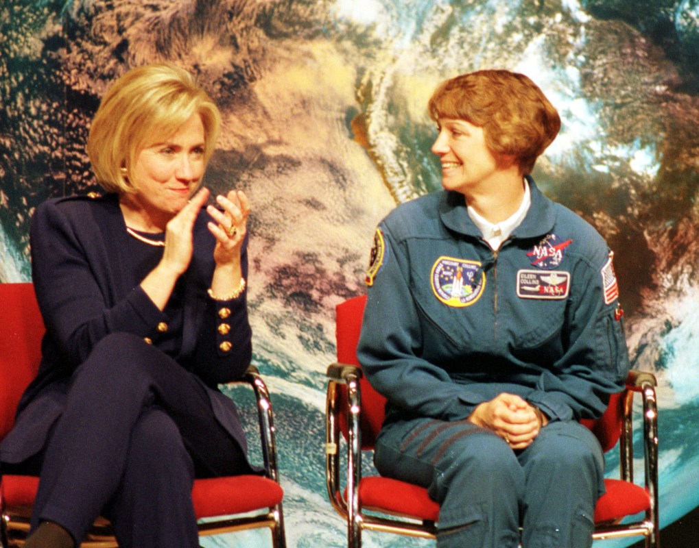 First lady Hillary Rodham Clinton (L) applauds astronaut Eileen Collins during a visit with science students at Dunbar High School March 5, 1998 in Washington, DC. Collins has been named the first woman commander of a NASA mission which will launch in April of 1999. (photo by Karin Cooper)