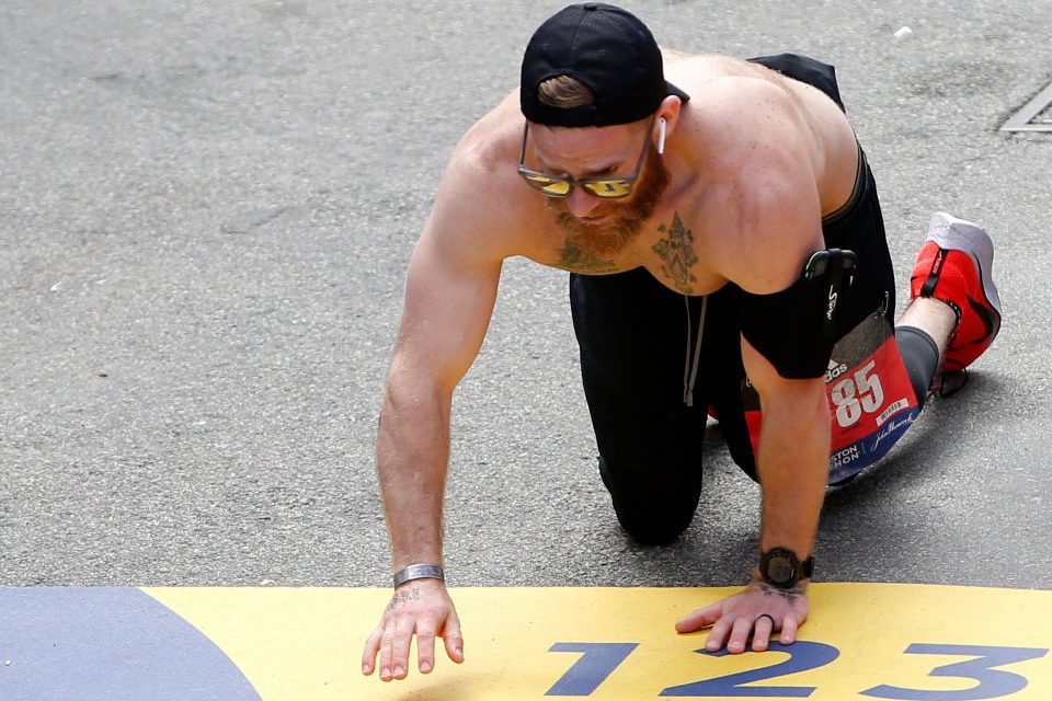 Micah Herndon crawls across the finish line of the 123rd Boston Marathon. (Jessica Rinaldi/The Boston Globe via Getty Images)