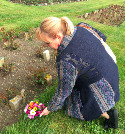 Author Jo Vigor-Mungovin leaves flowers at the unmarked grave of "Elephant Man" Joseph Merrick, which she recently discovered in the City of London Cemetery. (Screenshot: Twitter)