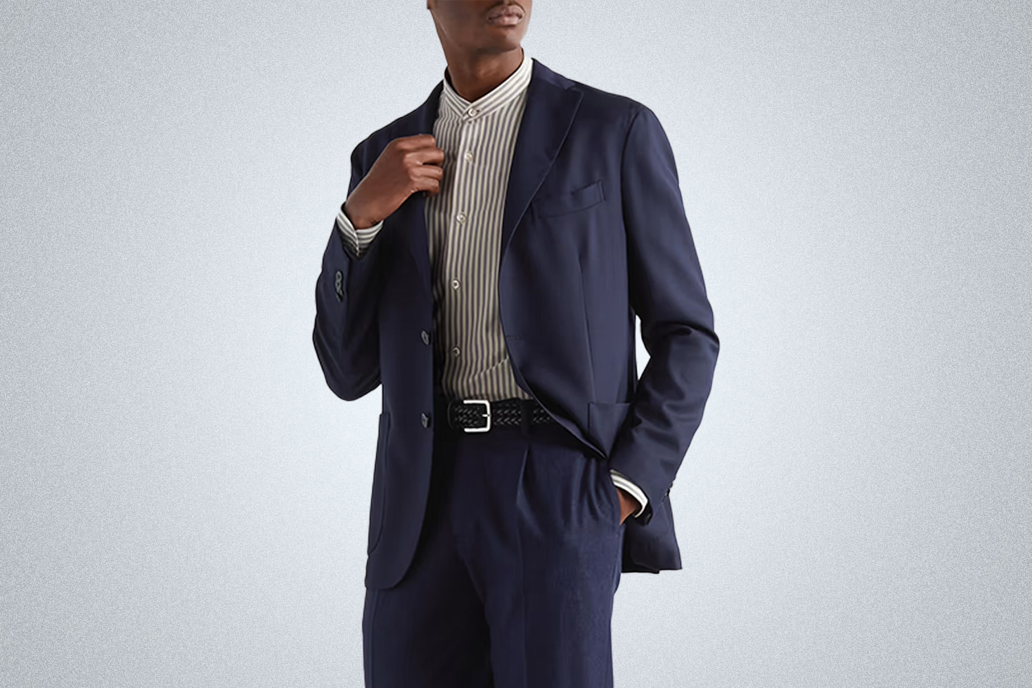a model in a blue Boglioli travel blazer on a grey background