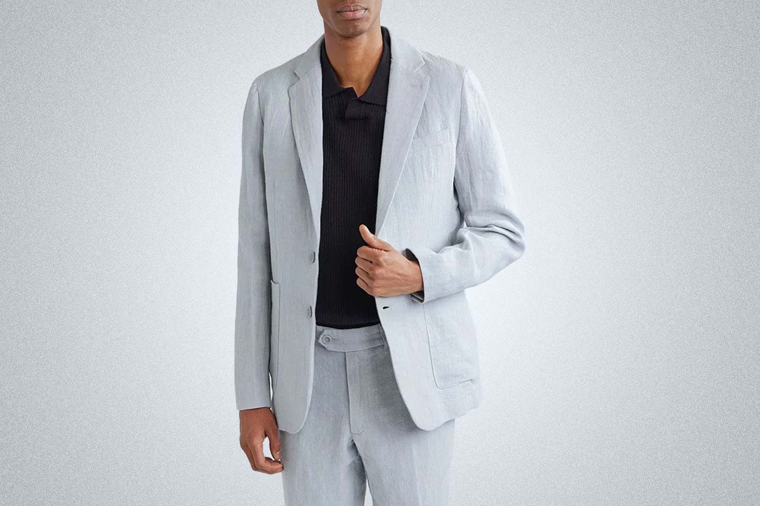 a model in a light blue Percival travel blazer on a grey background