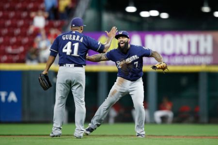 Eric Thames #7 and Junior Guerra #41 of the Milwaukee Brewers celebrate after clinching a playoff berth following a 9-2 win over the Cincinnati Reds at Great American Ball Park on September 25, 2019 in Cincinnati, Ohio. (Photo by Joe Robbins/Getty Images)