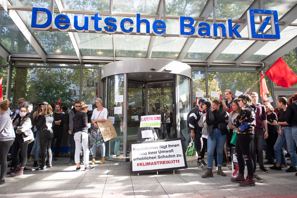 20 September 2019, Baden-Wuerttemberg, Stuttgart: Participants in a demonstration block the entrance to a Deutsche Bank branch. The demonstrators follow the call of the movement Fridays for Future and want to fight for more climate protection. They want to support the calls for strikes and protests all over the world. Photo: Sebastian Gollnow/dpa (Photo by Sebastian Gollnow/picture alliance via Getty Images)