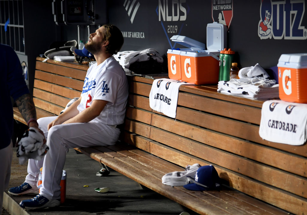 Clayton Kershaw of the Los Angeles Dodgers sits in the dug out after leaving the game after giving up back to back home runs in the eighth inning of game five of the National League Division Series against the Washington Nationals at Dodger Stadium on October 09, 2019 in Los Angeles, California. (Photo by Harry How/Getty Images)