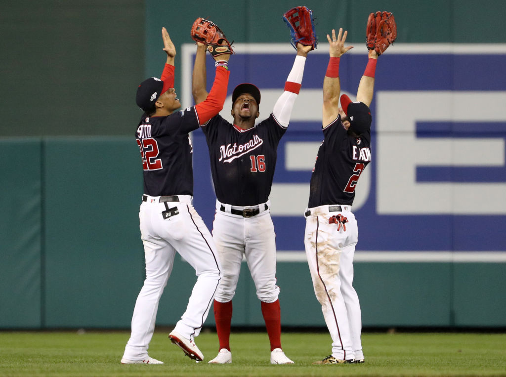 Juan Soto #22, Victor Robles #16, and Adam Eaton #2 of the Washington Nationals celebrate defeating the St. Louis Cardinals 8-1 after game three of the National League Championship Series at Nationals Park on October 14, 2019 in Washington, DC. (Photo by Patrick Smith/Getty Images)