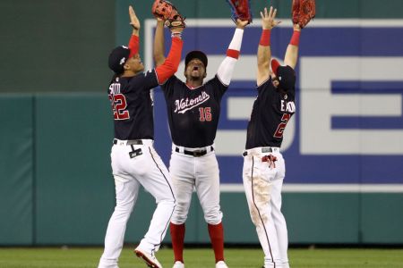 Juan Soto #22, Victor Robles #16, and Adam Eaton #2 of the Washington Nationals celebrate defeating the St. Louis Cardinals 8-1 after game three of the National League Championship Series at Nationals Park on October 14, 2019 in Washington, DC. (Photo by Patrick Smith/Getty Images)