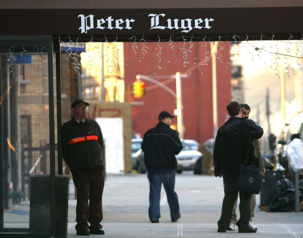 People walk past the Peter Luger steakhouse December 29, 2003 in New York City. (Photo by Spencer Platt/Getty Images)