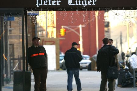 People walk past the Peter Luger steakhouse December 29, 2003 in New York City. (Photo by Spencer Platt/Getty Images)