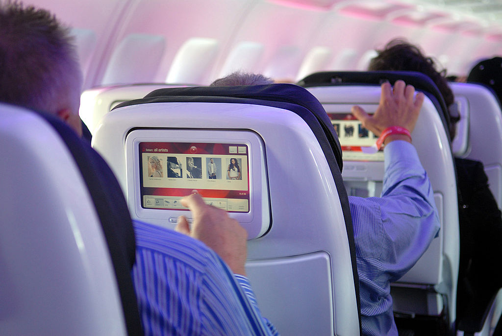 Passengers try out Virgin America airlines' in-flight entertainment system which includes on-demand movies, television, video games, music and onboard chat rooms during the first flights of Virgin America from Los Angeles and New York to its base of operations in San Francisco, California, Wednesday, August 8, 2007. (Photo by Bob Riha/WireImage)