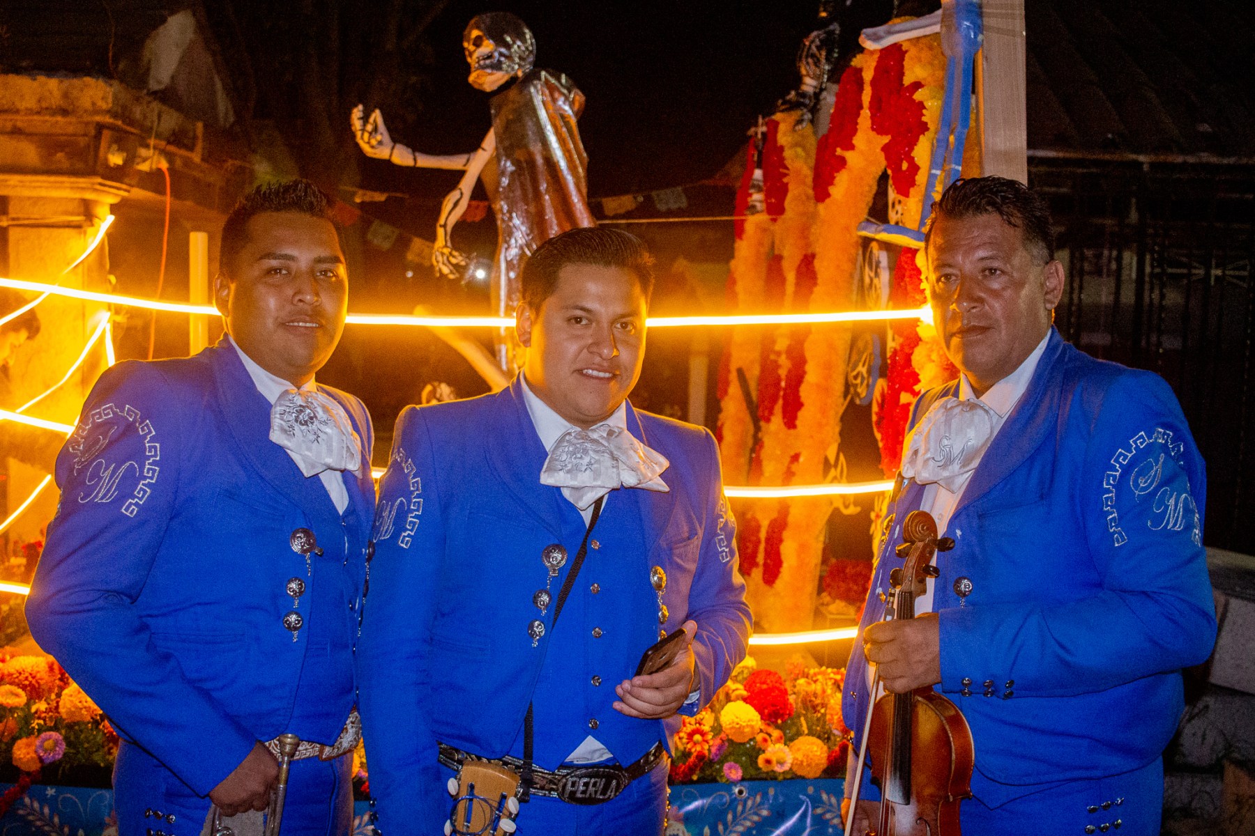 On the night of November 1st, the cemetery turns into a literal party, with relatives gathering to celebrate the lives of the deceased. Live music, such as that of these mariachis, is quite prevalent, as are <em>chelas</em>, aka beers.