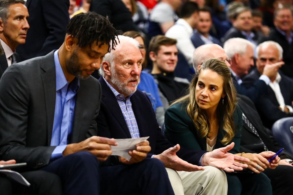 (L-R) Tim Duncan, Gregg Popovitch, and Becky Hammon of the San Antonio Spurs talk during the second quarter of the game against the Minnesota Timberwolves at Target Center on November 13, 2019 in Minneapolis, Minnesota. (Photo by David Berding/Getty Images)