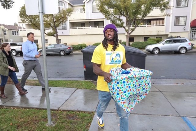 Melvin arriving to Pathways of Hope with wrapped in-need items the shelter requested for residents 