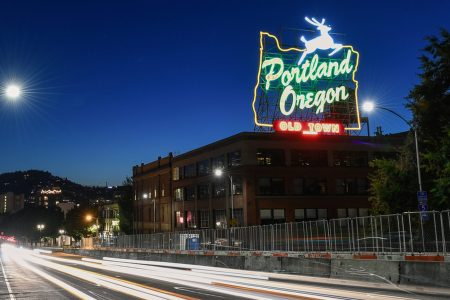 The Portland White Stag sign illuminated at night over Burnside Bridge. (Travel Portland)