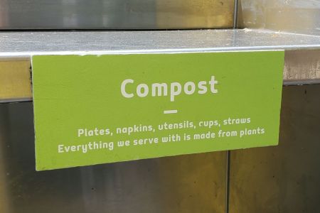 Sign above compost bin in restaurant in Dublin, California, stating that all silverware and other serving ware is made from compostable materials, July 30, 2019. (Photo by Smith Collection/Gado/Getty Images)