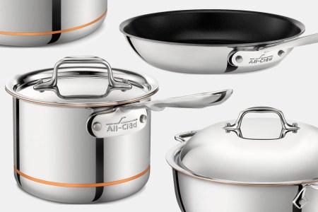 All-Clad Copper Core, stainless steel and nonstick pots and pans on a grey background. All of them are on sale at the Home & Cook website.