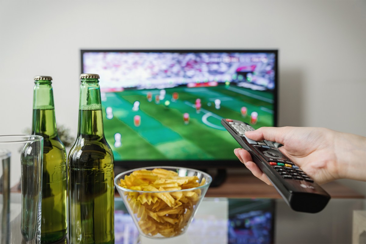 Watching television with beer, chips and remote control