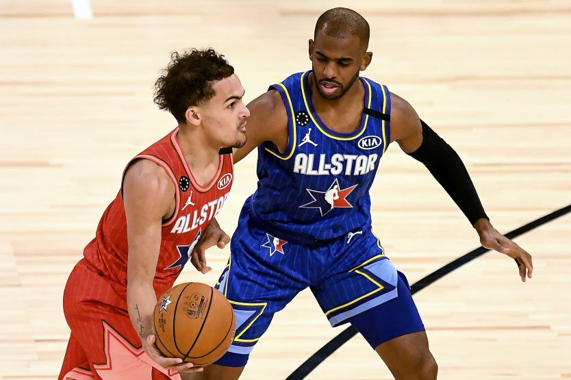 Trae Young dribbles the ball while being guarded by Chris Paul. (Stacy Revere/Getty)