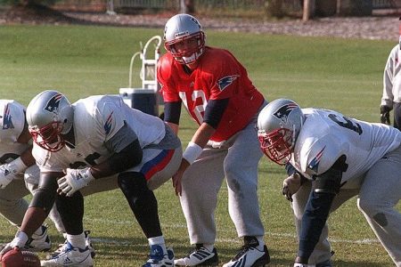 Tom Brady takes snaps during practice while Drew Bledsoe looks on. (Bill Greene/The Boston Globe via Getty)