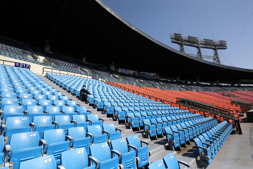 An employee of LG Twins watches a game at an empty stadium. (Chung Sung-Jun/Getty)