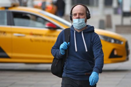 A man walks with a face mask on