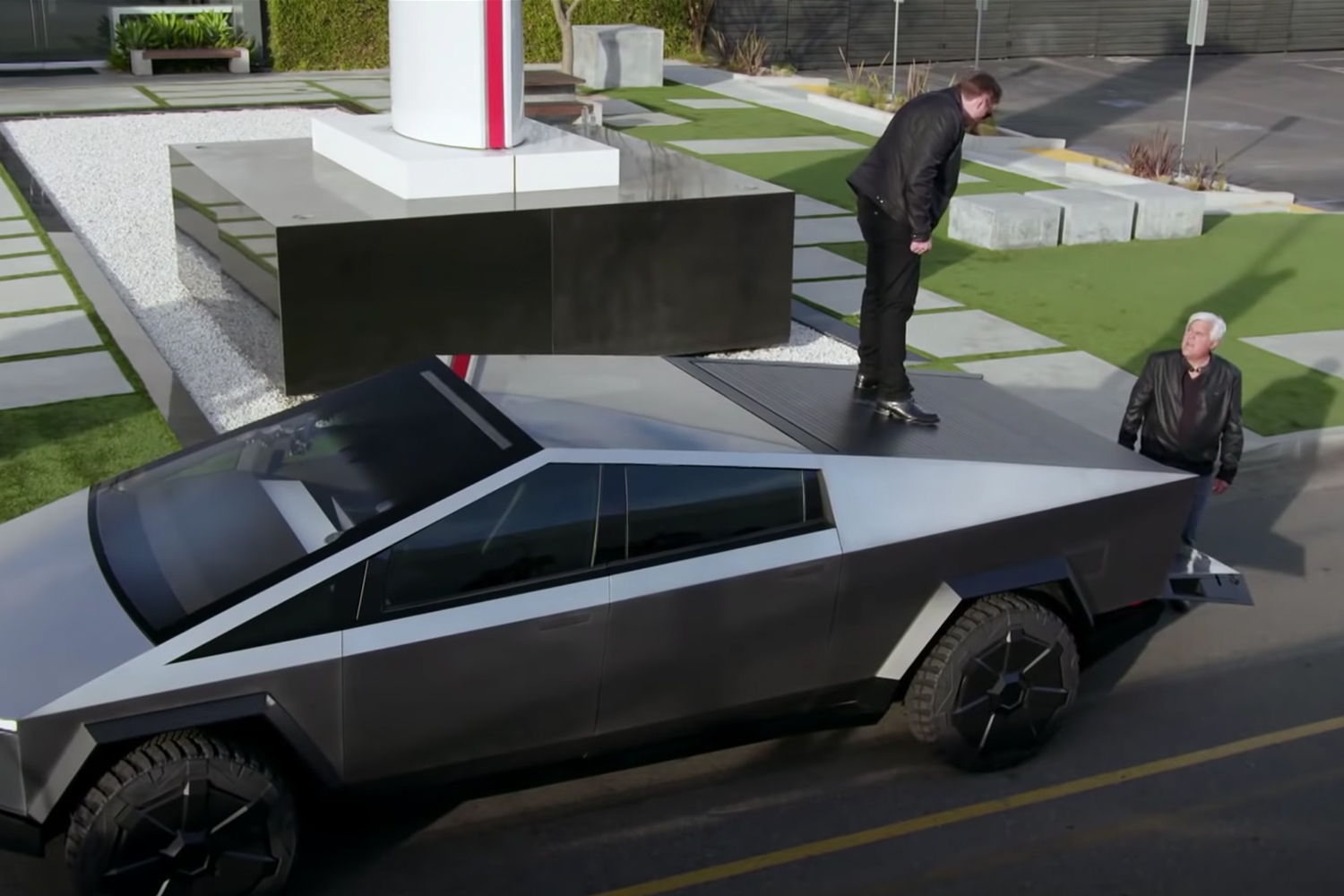 Elon Musk stands on the Cybertruck bed cover next to Jay Leno
