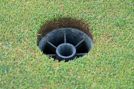 Holes on the greens with upside down "flagstick cups." (David Cannon/Getty)