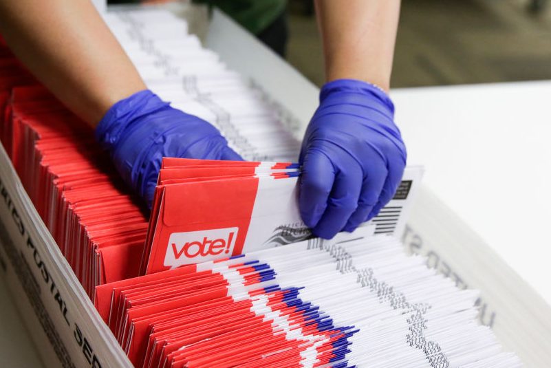 Election workers sort vote-by-mail ballots