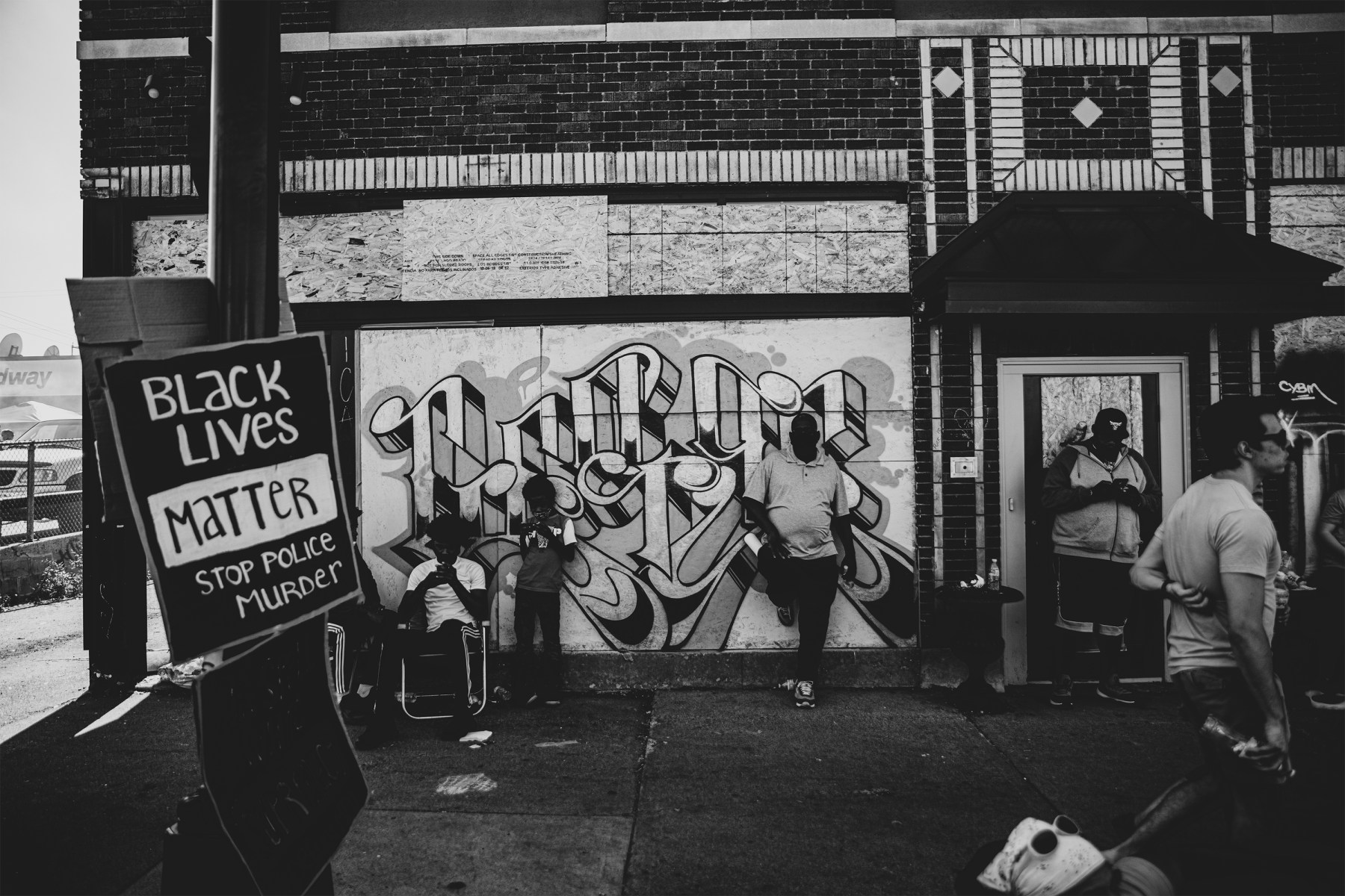 Displays of solidarity take the form of old-school graffiti and makeshift cardboard signs.