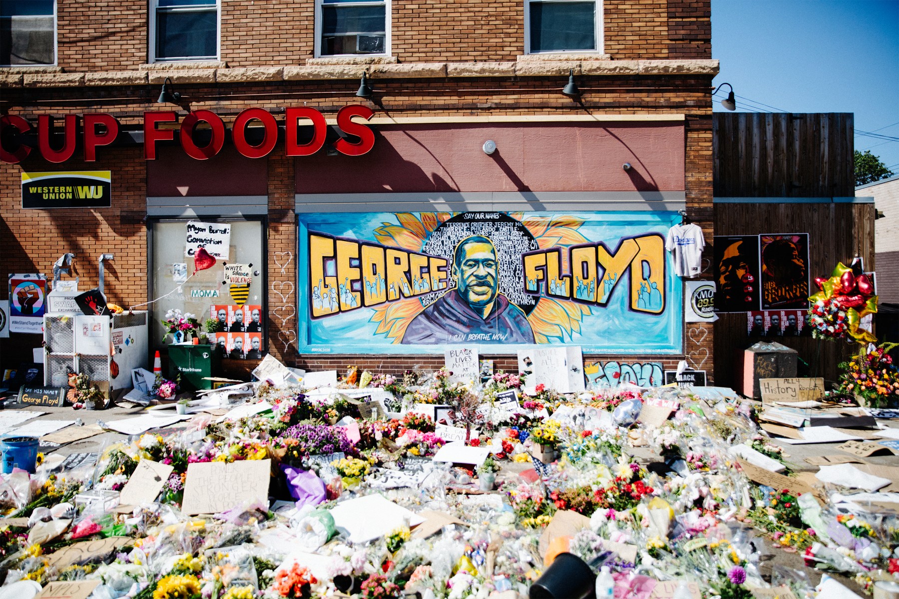 The George Floyd memorial, outside the convenience store where he was murdered, grows every day.