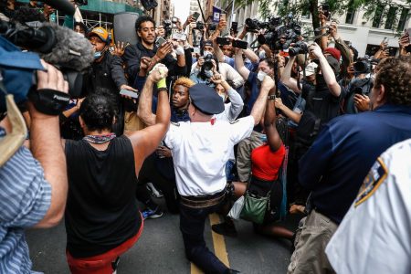 A police officer kneeling among protestors