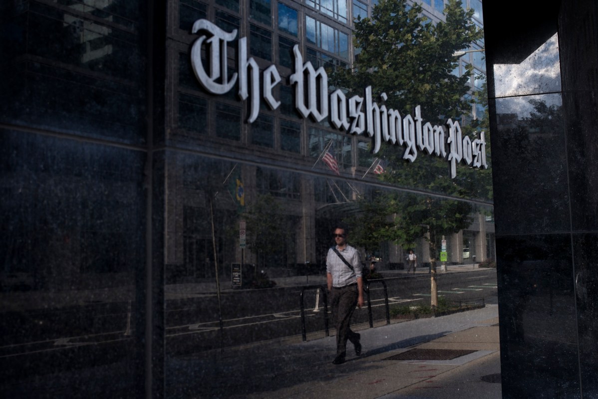 A man walks past The Washington Post. (Photo by BRENDAN SMIALOWSKI/AFP via Getty Images)