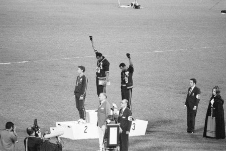 Tommie Smith and John Carlos, gold and bronze medalists in the 200-meter run at the 1968 Olympic Games, engage in a victory stand protest against unfair treatment of Black people in the United States.