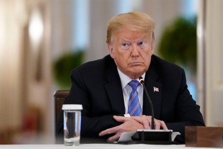 President Donald Trump sits behind a microphone in the East Room of the White House in June, 2020