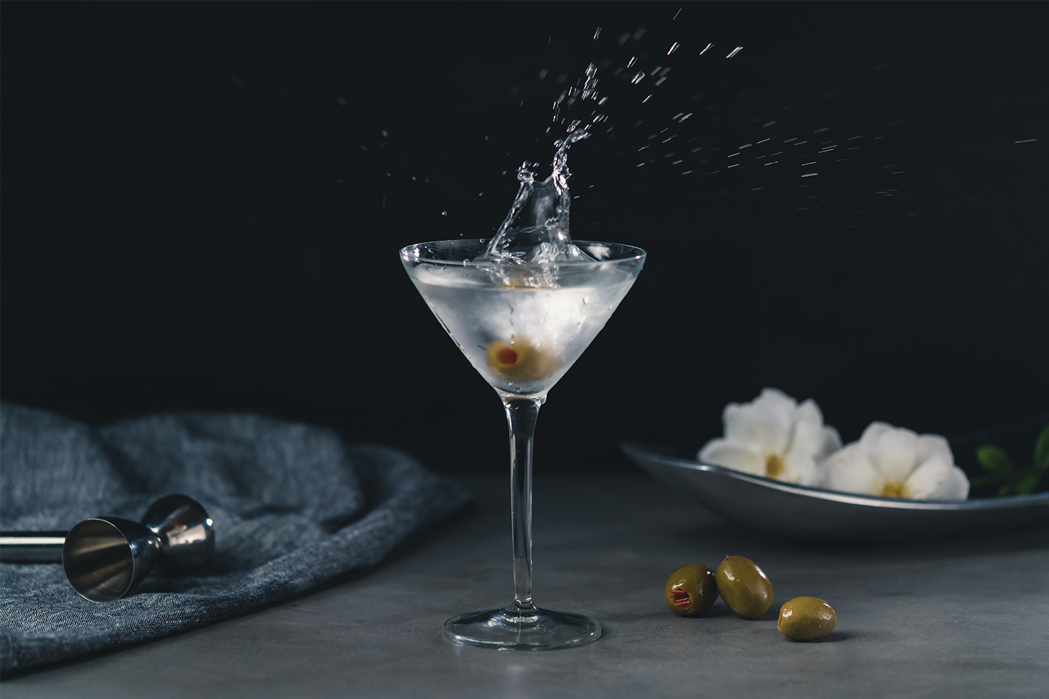 A gin martini with an olive thrown in the glass