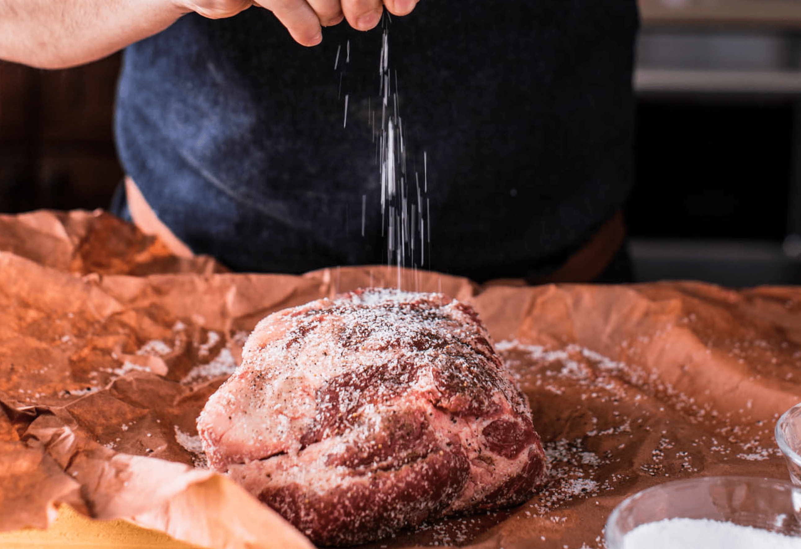 Pork shoulder being seasoned.