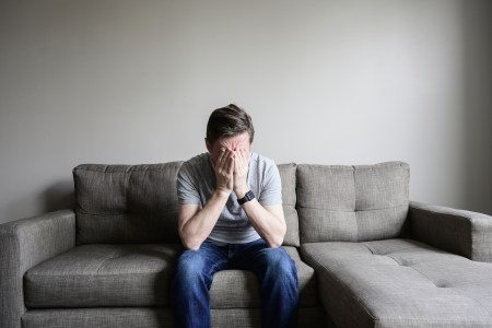 unhappy person sitting on couch in despair