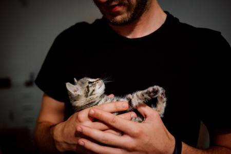 man cradling cat