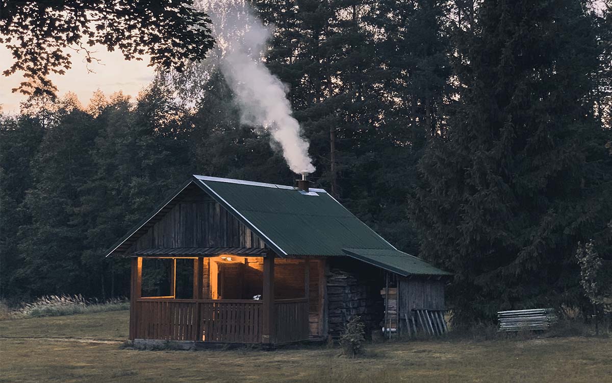 A rural cabin with smoke coming out of the chimney