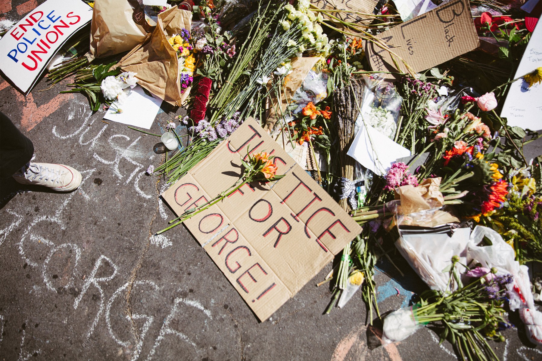Flowers, protest signs, heartfelt cards and other ephemera make up the memorial.