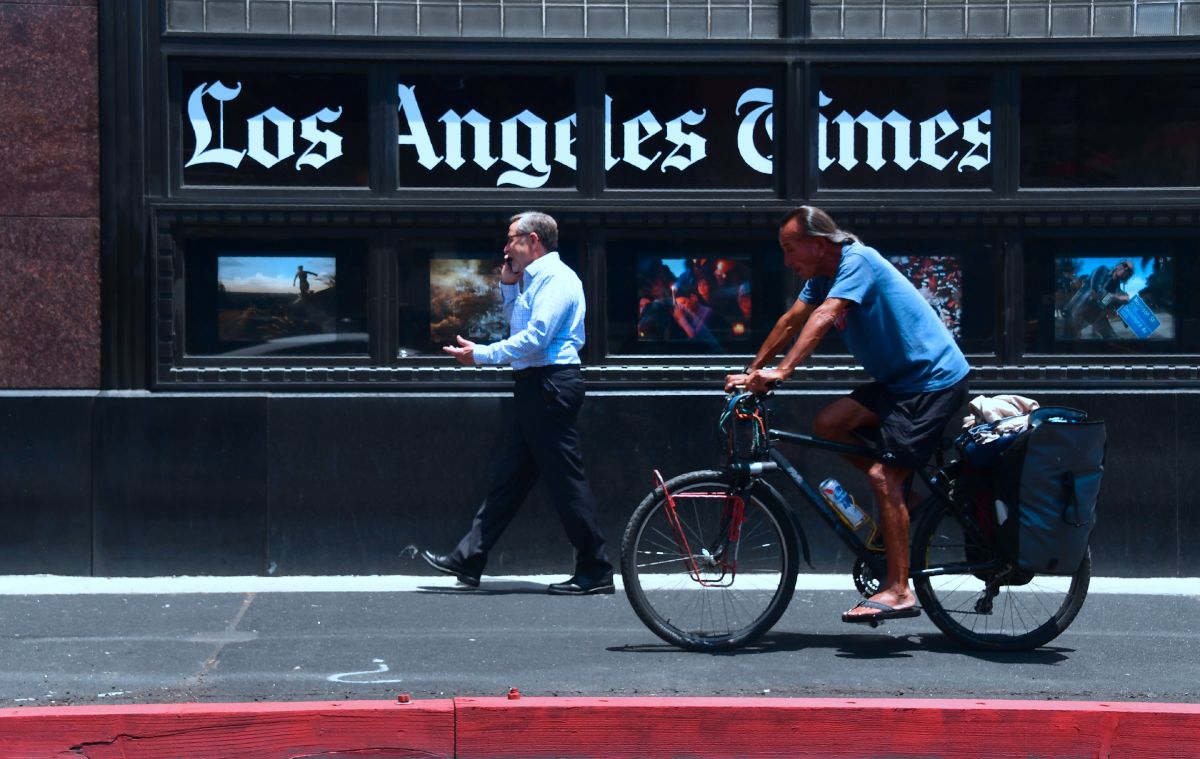 People make their way past the Los Angeles Times office building in downtown Los Angeles, California on July 16, 2018. (Photo by Frederic J. BROWN / AFP)